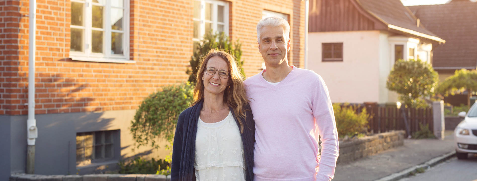 Man och kvinna som står framför tegelhus. 