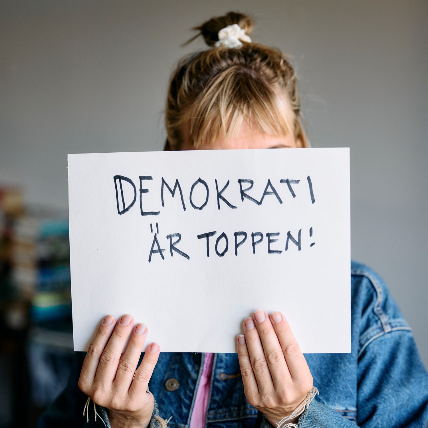 Kvinna håller upp skylt med budskap om demokrati