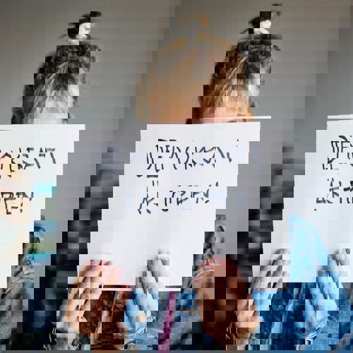 Kvinna håller upp skylt med budskapet "Demokrati är toppen!"