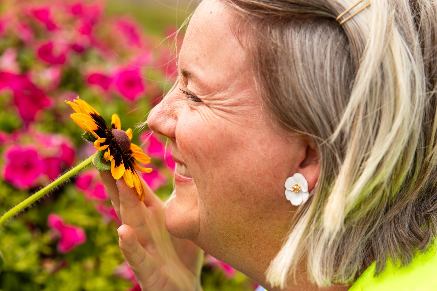 Anna doftar på en blomma.