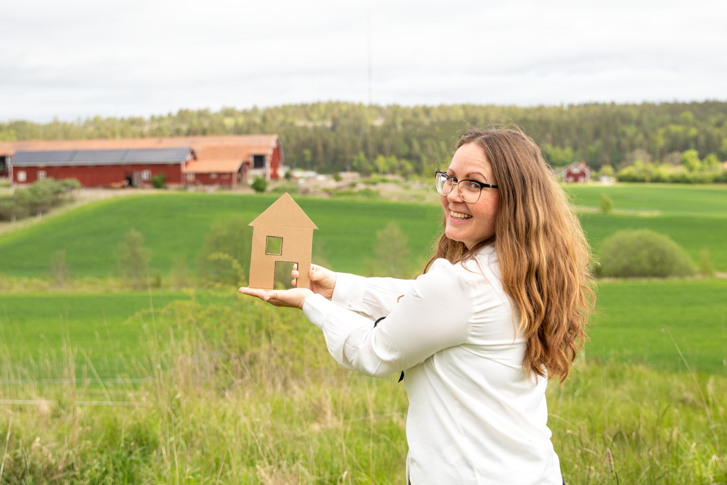 En modell på ett hus i kartong över ett fält.