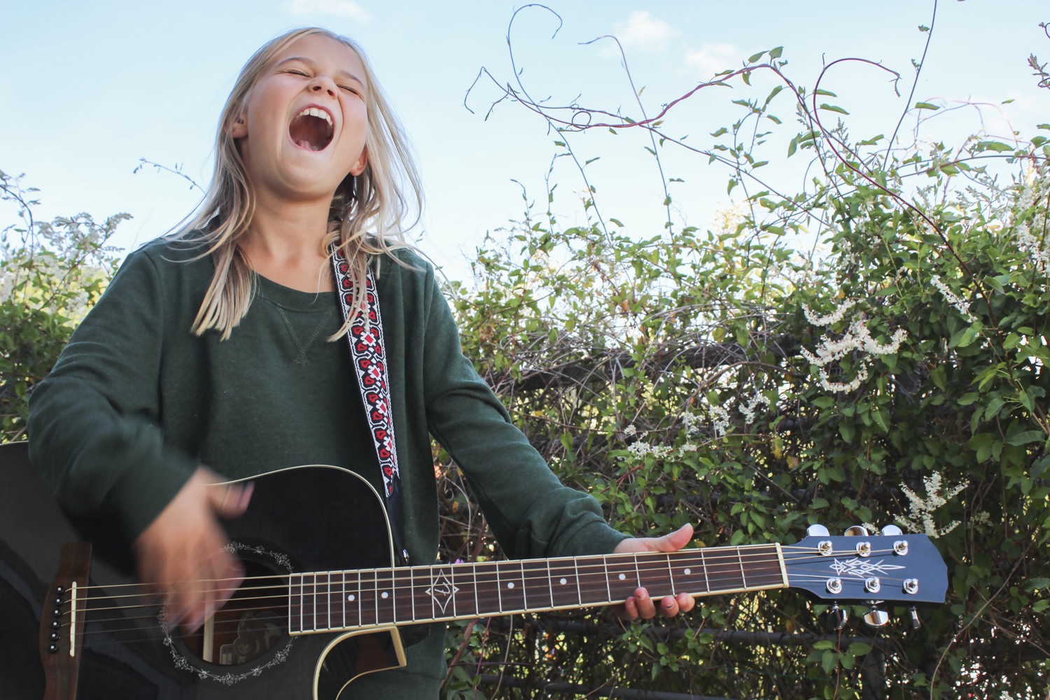 Flicka spelar gitarr och sjunger.
