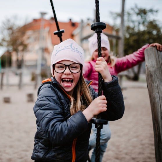 Glada flickor leker i lekpark.