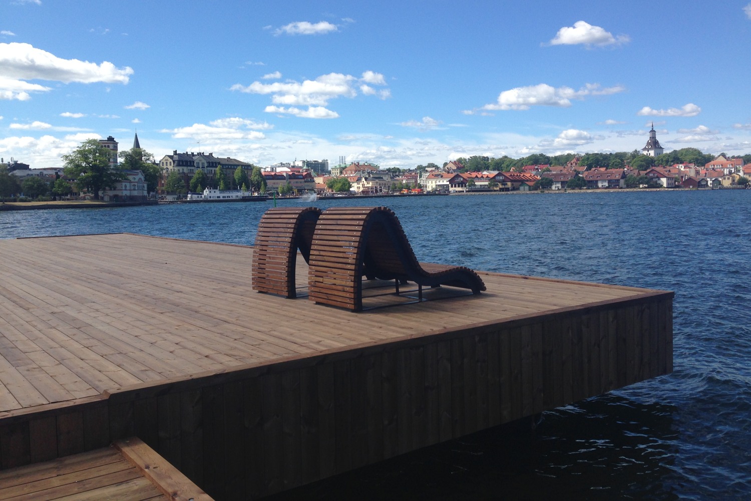 Träsoffor med utsikt över vattnet.