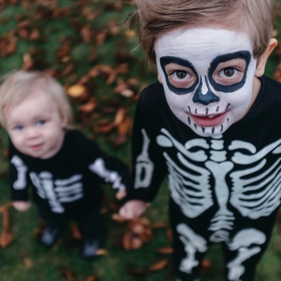 Två små pojkar med målade ansikten i halloweendräkt.
