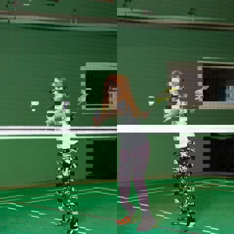 Flicka som spelar badminton.