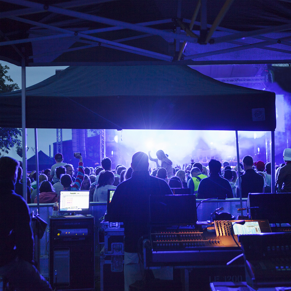 bild på en mixplats framför publik och en scen på ett musikevenemang